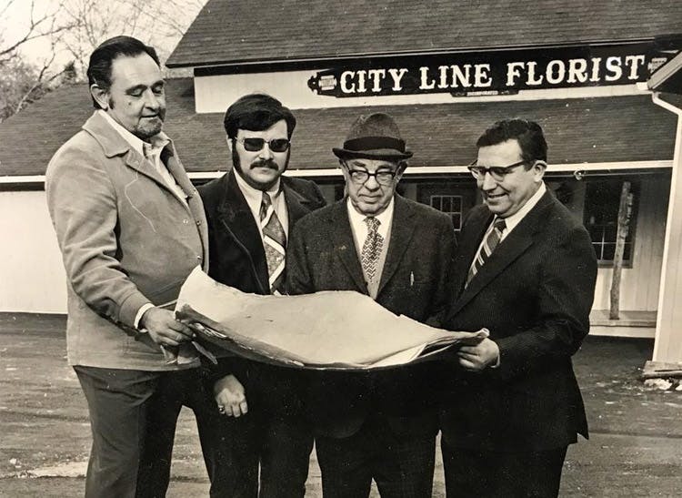 Four members of the ownership team, looking over a blueprint together in the 1970s